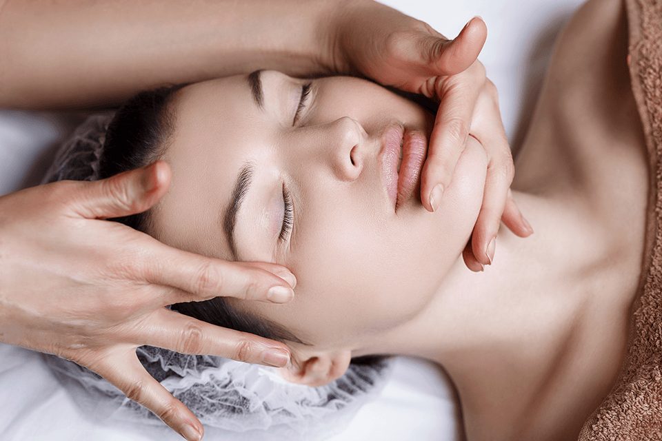 Gezichtsmassage tijdens een behandeling in de salon
